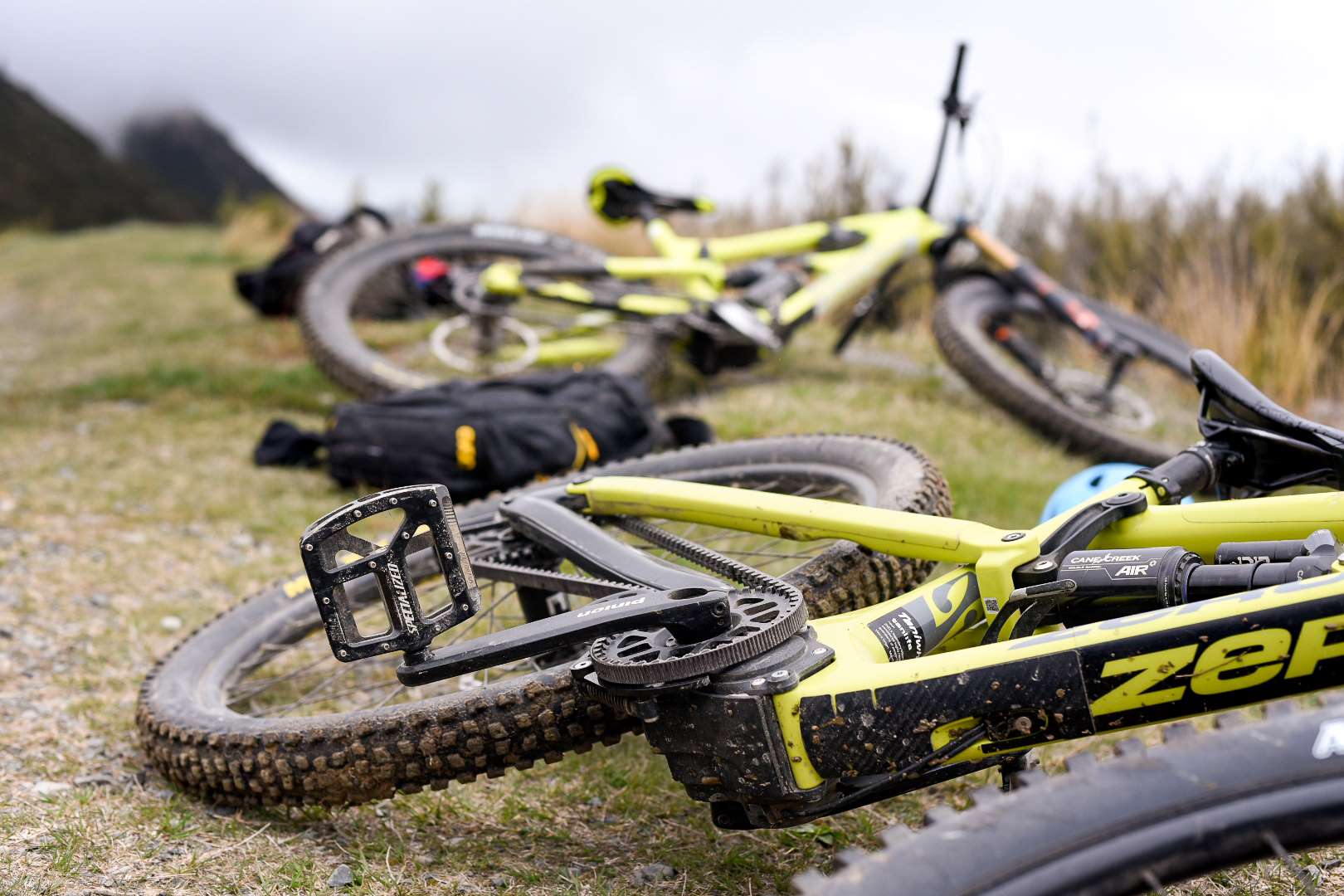 A lime green Zerode Taniwha lies on its side on a trail